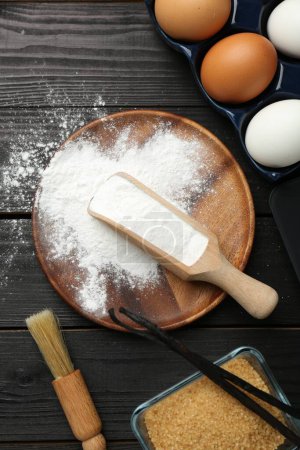 Flat lay composition with baking powder and products on black wooden table