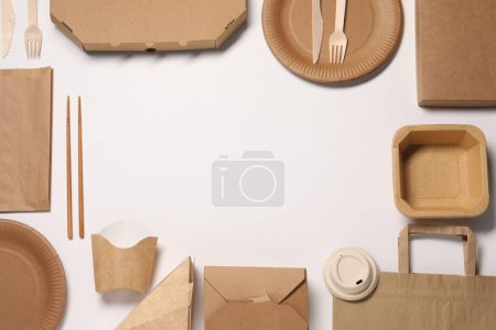 Eco friendly food packaging. Frame of paper containers, bags and tableware on white background, flat lay. Space for text