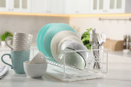 Vajilla, vasos y cubiertos diferentes en la mesa de mármol blanco en la cocina