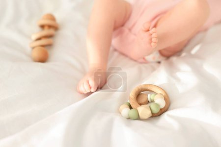 lindo bebé y sonajero juguetes en sábanas, primer plano