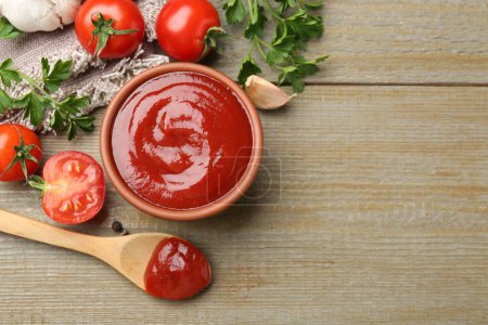 Photo for Tasty ketchup, fresh tomatoes, parsley and spices on wooden table, flat lay. Space for text - Royalty Free Image