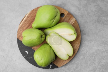 Photo for Cut and whole chayote on gray table, top view - Royalty Free Image