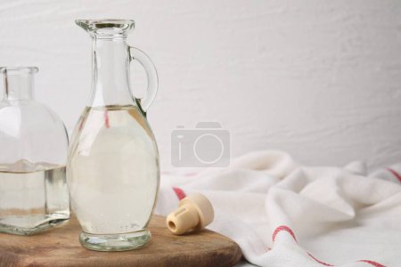 Foto de Vinagre en jarra de vidrio y botella sobre mesa, espacio para texto - Imagen libre de derechos