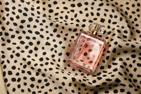 Téléchargez les photos : Parfum de luxe en bouteille sur tissu avec motif léopard, vue de dessus - en image libre de droit