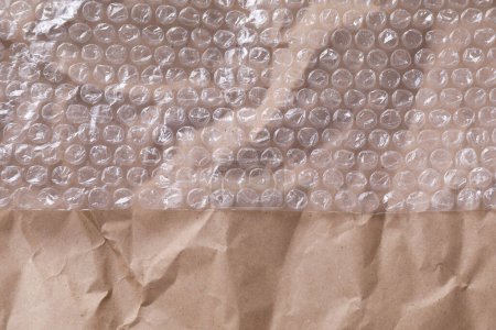 Transparent bubble wrap on kraft paper, top view. Space for text