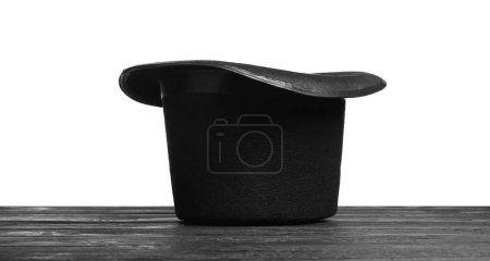 Magician's hat on wooden table against white background