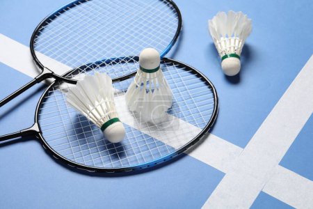 Photo for Feather badminton shuttlecocks and rackets on blue background - Royalty Free Image