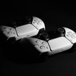 Two wireless game controllers on black background