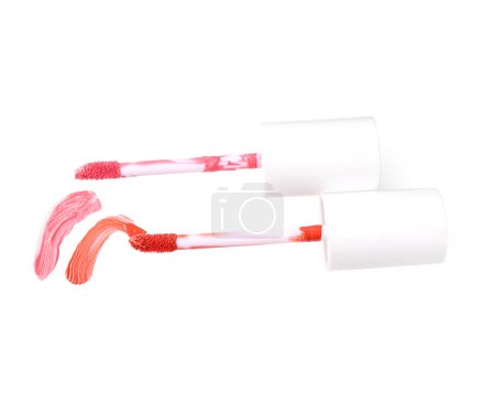 Foto de Pinceladas de brillo de labios de color y aplicadores aislados en blanco - Imagen libre de derechos