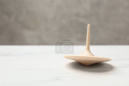 One spinning top on white table, closeup. Space for text