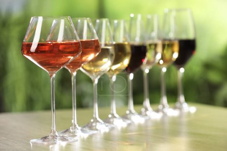 Téléchargez les photos : Différents vins savoureux dans des verres sur une table en bois, espace pour le texte - en image libre de droit