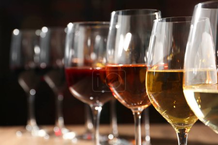 Photo for Different tasty wines in glasses against blurred background, closeup - Royalty Free Image