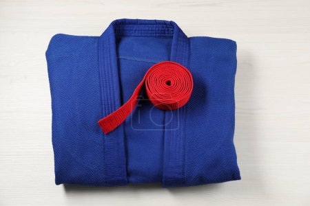 Téléchargez les photos : Ceinture karaté rouge et kimono bleu sur fond bois, vue de dessus - en image libre de droit