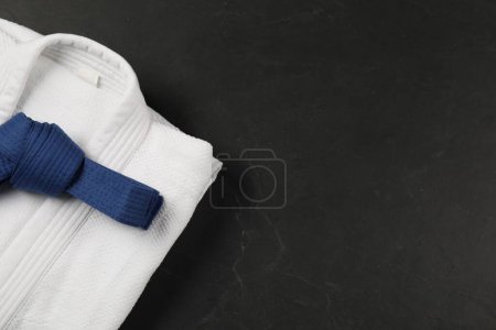Photo for Blue karate belt and white kimono on gray background, top view. Space for text - Royalty Free Image