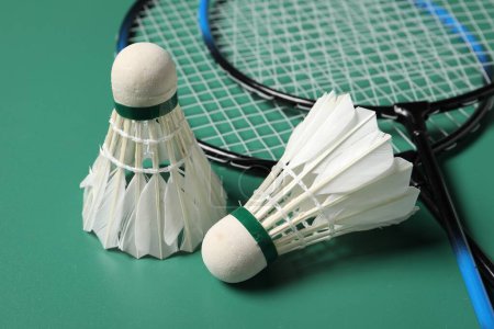 Photo for Feather badminton shuttlecocks and rackets on green background, closeup - Royalty Free Image