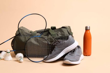 Photo for Badminton set, bag, sneakers and bottle on beige background - Royalty Free Image