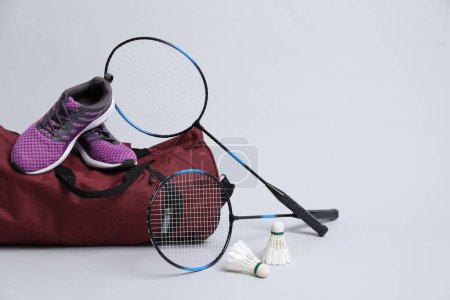 Photo for Feather badminton shuttlecocks, rackets, bag and sneakers on gray background - Royalty Free Image