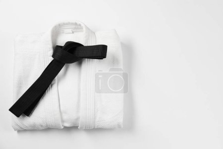 Téléchargez les photos : Ceinture de karaté noire et kimono sur fond blanc, vue de dessus. Espace pour le texte - en image libre de droit