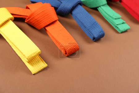 Photo for Colorful karate belts on brown background, closeup. Space for text - Royalty Free Image