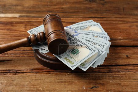 Richtergabel und Geld auf Holztisch