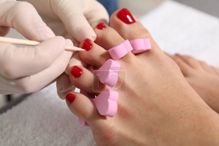 Foto de Pedicura trabajando con las uñas de los pies del cliente en el salón de belleza, primer plano - Imagen libre de derechos