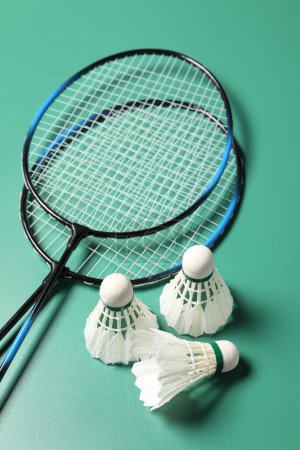 Photo for Feather badminton shuttlecocks and rackets on green background - Royalty Free Image