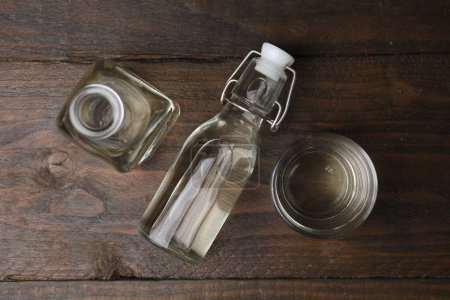 Foto de Vinagre en botellas y vidrio sobre mesa de madera, plano - Imagen libre de derechos