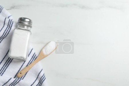 Photo for Shaker with salt on white marble table, flat lay. Space for text - Royalty Free Image