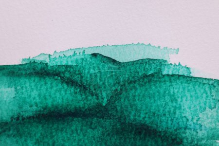 Peinture à l'aquarelle verte abstraite sur papier blanc, vue du dessus