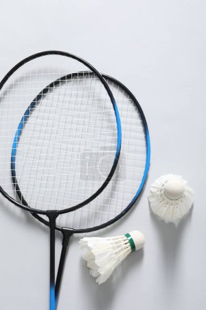 Photo for Feather badminton shuttlecocks and rackets on gray background, flat lay - Royalty Free Image