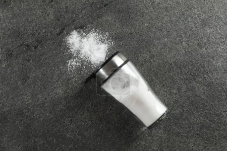 Photo for Salt shaker on grey textured table, top view - Royalty Free Image