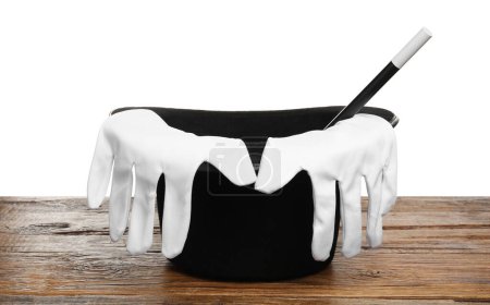 Chapeau de magicien, gants et baguette sur table en bois sur fond blanc