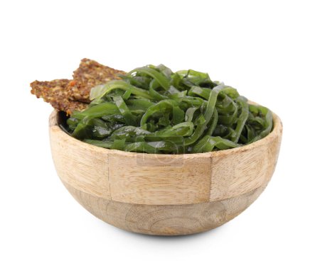 Tasty seaweed salad and crispbreads in bowl isolated on white