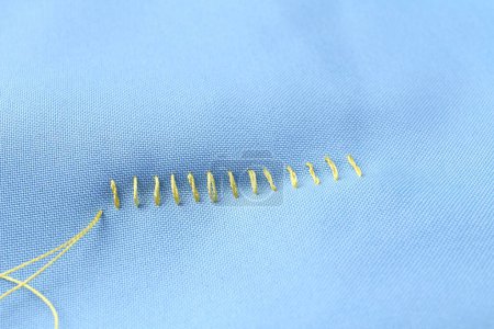 Téléchargez les photos : Fil à coudre et points de suture sur tissu bleu clair, vue ci-dessus - en image libre de droit