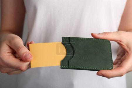 Téléchargez les photos : Femme tenant le titulaire de la carte de visite en cuir avec carte, gros plan - en image libre de droit