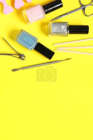 Téléchargez les photos : Vernis à ongles et ensemble d'outils de pédicure sur fond jaune, pose plate. Espace pour le texte - en image libre de droit
