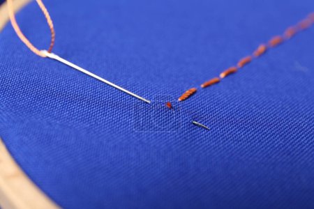 Téléchargez les photos : Aiguille à coudre avec fil et points de suture sur tissu bleu, gros plan - en image libre de droit