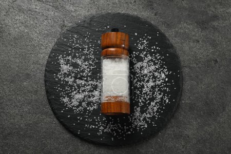 Photo for Salt shaker on grey textured table, top view - Royalty Free Image