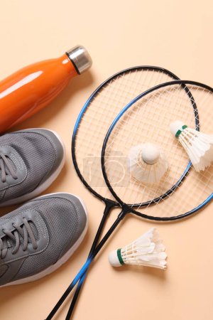 Photo for Feather badminton shuttlecocks, sneakers and bottle on beige background, flat lay - Royalty Free Image