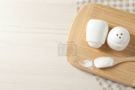 Photo for Spice shakers with salt on white wooden table, top view. Space for text - Royalty Free Image