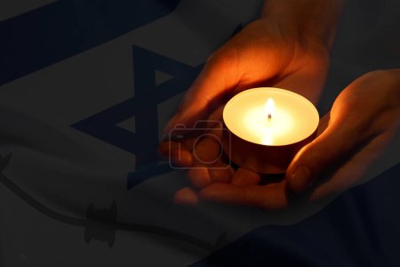 Holocaust-Gedenktag. Doppelentblößung der israelischen Flagge und Frau mit brennender Kerze