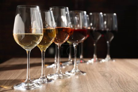Téléchargez les photos : Différents vins savoureux dans des verres sur une table en bois, espace pour le texte - en image libre de droit
