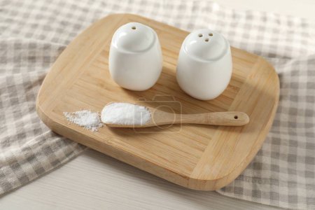 Photo for Spice shakers with salt on white wooden table - Royalty Free Image