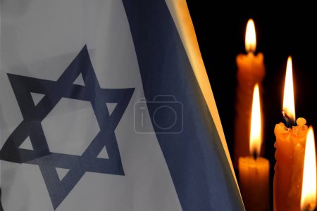 Holocaust-Gedenktag. Flagge Israels und brennende Kerzen