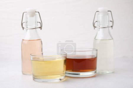 Different types of vinegar on light table, closeup