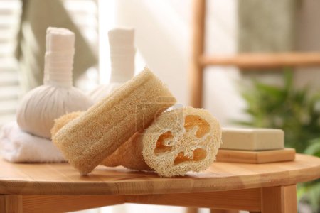 Loofah sponges on wooden table indoors, closeup. Personal hygiene products