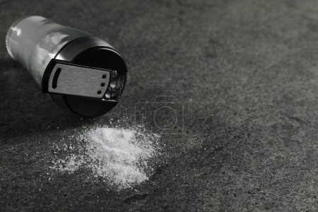 Photo for Salt shaker on grey textured table, closeup. Space for text - Royalty Free Image