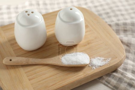 Spice shakers with salt on white table