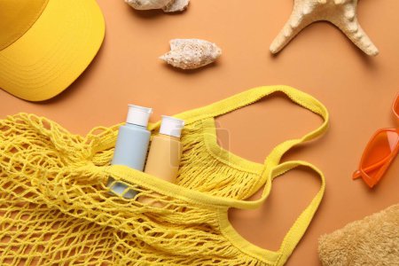 Foto de Bolso de cuerda y diferentes accesorios de playa sobre fondo naranja pálido, plano - Imagen libre de derechos