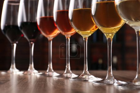Téléchargez les photos : Différents vins savoureux dans des verres sur une table en bois - en image libre de droit